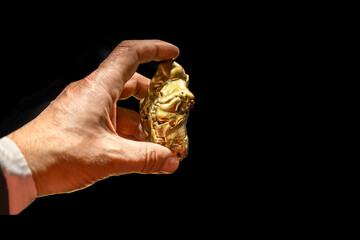 Man in formal suit holding gold nugget in hands. Successful startup, wealth, treasure, find,...