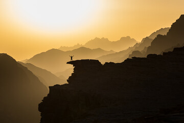 Sonnenuntergang über dem Al Shaq canyon, Ash Shaq Canyon in Saudi Arabien mit Person auf einem...