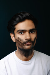 Conceptual portrait of a man with a black handprint on his face, symbolizing silence, social...