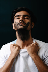 Conceptual portrait of a man with a black handprint on his face, symbolizing silence, social issues, and emotional awareness in an artistic style.

