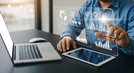 Man analyzing data with modern technology showing graphs, charts, and a laptop at his work space in an office, a future business opportunity.