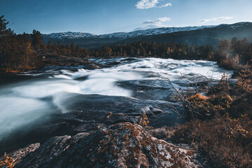 long exposure waterfall in norway with trees in background