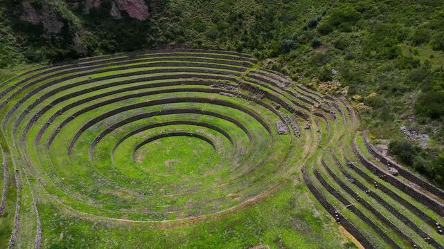 Aerial approach and orbit of Moray&rsquo;s iconic circular Inca terraces in Peru, revealing the ancient agricultural concentric design in the Sacred Valley