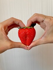 hands holding red heart By strawberry