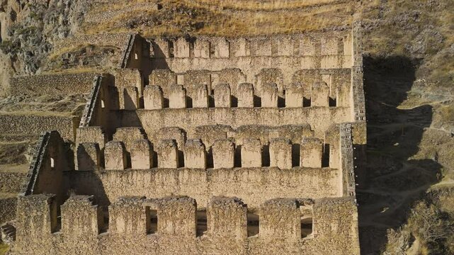 Ollantaytambo&rsquo;s iconic Inca terraces and stone fortress Pinkuylluna, revealing dramatic elevation and the breathtaking Sacred Valley landscape in Peru -aerial parallax shot