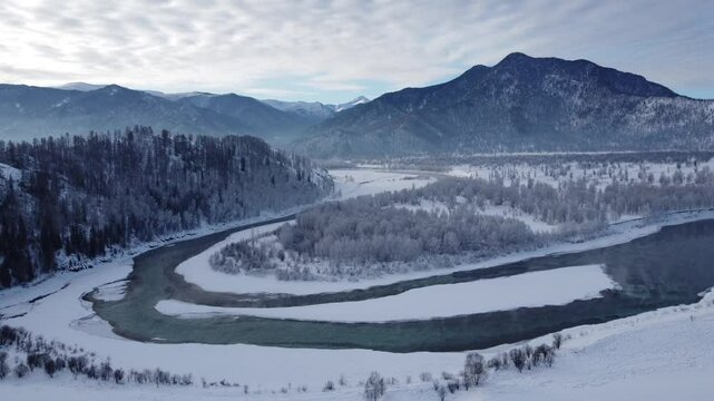 Drone footage of snowy mountains, valleys, and forests in Ust-Koksa, Altai Republic, Russia, under clear skies, showing the remote region&rsquo;s beauty during winter.