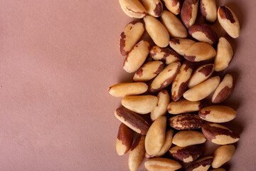 Brazil nuts scattered on beige mocha background with space for text. Tasty and healthy food....