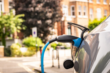 Electric car being charged on upmarket British residential street