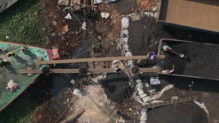 Dhaka, Bangladesh - 01 March 2025: Aerial view of busy dockyard with cargo ships and trucks, Bangladesh.
