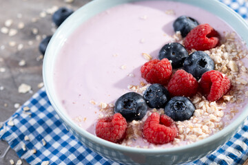 Healthy smoothie bowl with berries on wooden table. Close up