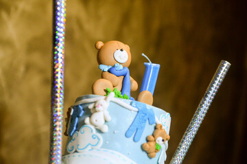 A three-tier blue and white birthday cake decorated with fondant, figurines in the shape of bears and a bunny with the male name Philip written in Cyrillic.