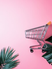Empty shopping cart and tropical leaves on pink background