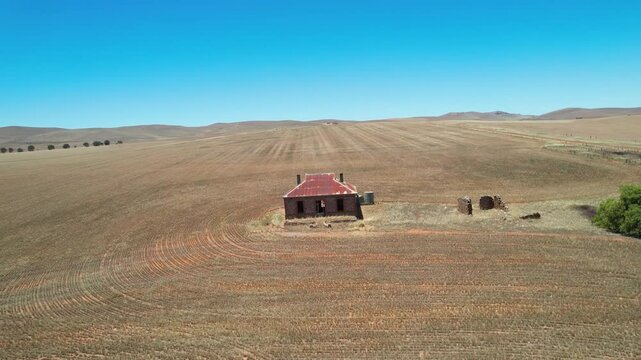 Aerial view of rustic house in dry farmland, Australia.