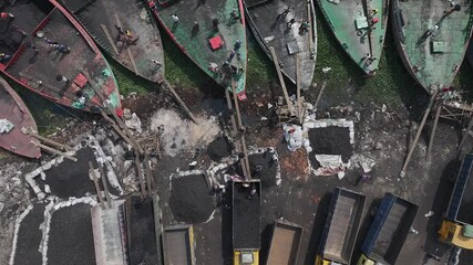 Dhaka, Bangladesh - 01 March 2025: Aerial view of busy dock with boats and trucks, Bangladesh.