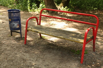 Ukraine. Kyiv. A bench in a summer park. There are many trees and bushes around.