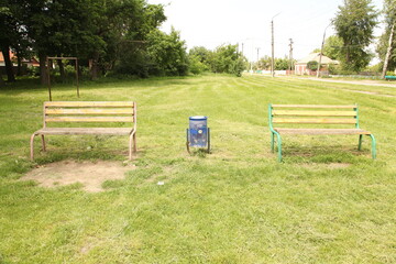 Ukraine. Kyiv. A bench in a summer park. There are many trees and bushes around.