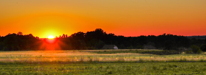 Here's another description option:
Golden sunset rays bathe a peaceful rural landscape, creating a...