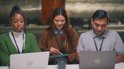 Attractive female entrepreneur leading a night office meeting with diverse programmers and colleagues, discussing project management, collaboration strategy, and financial success Tech business