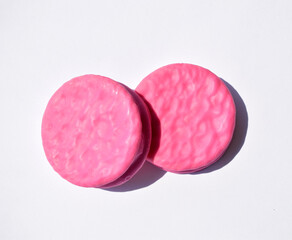 Pink round glazed biscuits isolated on white background, top view