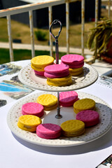 pink and yellow pies on a porcelain two-tiered plate