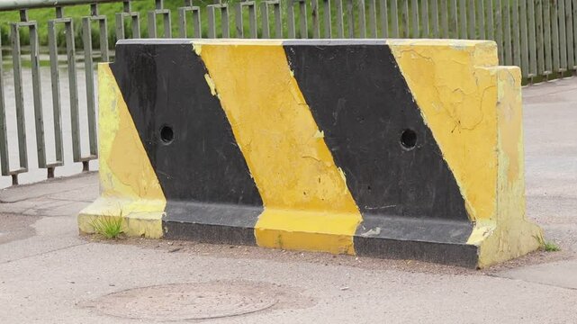 Concrete fence with yellow black coloring on bridge