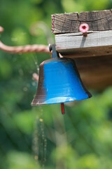 Blue bell hanging from a wooden post