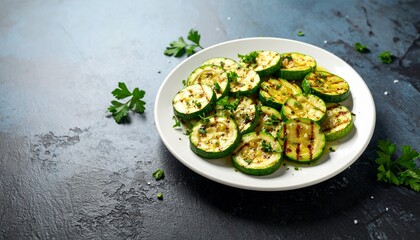 Grilled zucchini slices on a white plate, garnished with fresh herbs, presented on a dark background.
