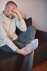 Man with ankle and foot pain at home.