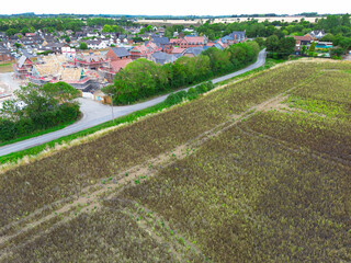 New housing development seen on sold farmland in rural Essex, UK. The near field has a crop which...