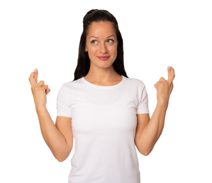 Young brunette woman in white t-shirt praying for luck with crossed arms and looking side over transparent background. PNG