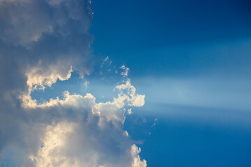 Landscape with the sun hidden behind the clouds on a summer day