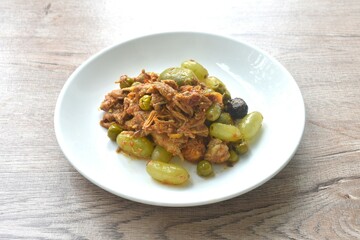 spicy fried roasted duck meat with grape and eggplant in curry on plate