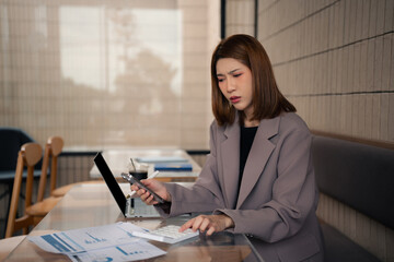 Business woman calculates financials with graph paper on the table on the cost.
