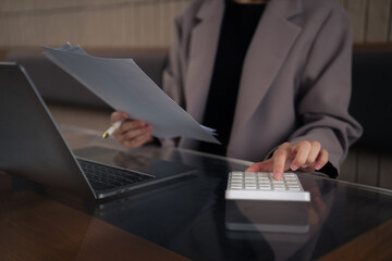 Business woman calculates financials with graph paper on the table on the cost.