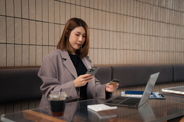 businesswoman use credit cards to conduct financial transactions through phones and laptop.