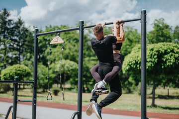 A man and woman engage in fitness activities on a pull-up bar at a park. The image conveys strength, teamwork, and motivation in an outdoor exercise environment.