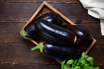 rustic still life with fresh eggplants and basil on a table