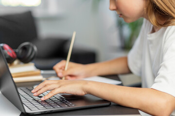 Girl typing on laptop and taking notes. Back to school.