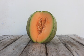 a melon that is cut open so that the orange flesh and many melon seeds are visible
