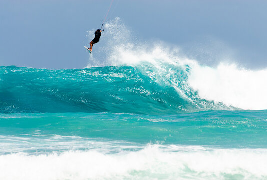 Kite surfer in the air at the top of wave