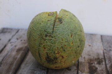 a melon that is cut open so that the orange flesh and many melon seeds are visible