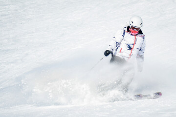 Woman Skier excited skiing downhill freeze fast motion on ski resort white slope pose carving in...