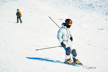 Skier skiing downhill in high mountains on a sunny day. Ski resort with snow at winter