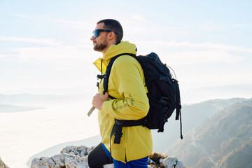 An extreme mountaineer, equipped with professional gear, pushes towards the peak of the mountain at...