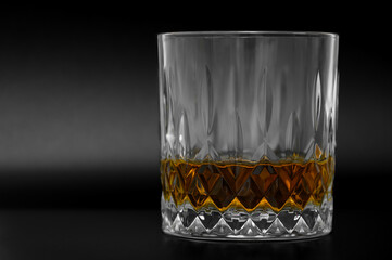 A glass of good whyskey on a black background, popular redhead, high-proof alcohol, alcoholism