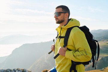 An extreme mountaineer, equipped with professional gear, pushes towards the peak of the mountain at...