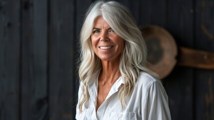 Fototapeta premium Elegant and mature woman with silver hair radiating confidence and warmth against dark backdrop