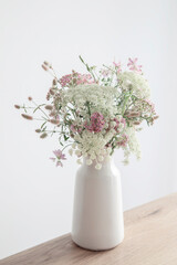 white and pink flowers in white vase on background white walll