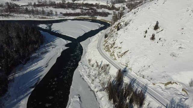 Drone footage of snowy mountains, valleys, and forests in Ust-Koksa, Altai Republic, Russia, under clear skies, showing the remote region&rsquo;s beauty during winter.