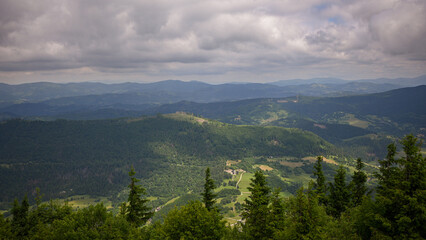 Stunning vista of forested mountains stretching to the horizon under a cloudy sky, showcasing the beauty of nature